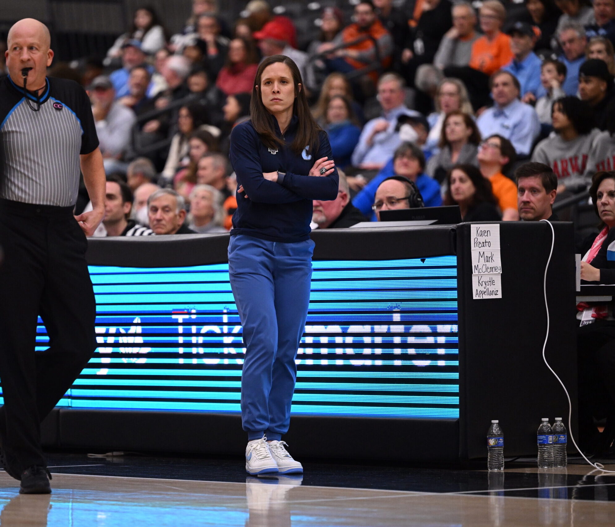 Columbia head coach Megan Griffith watches her team play with her arms crossed in front of her.