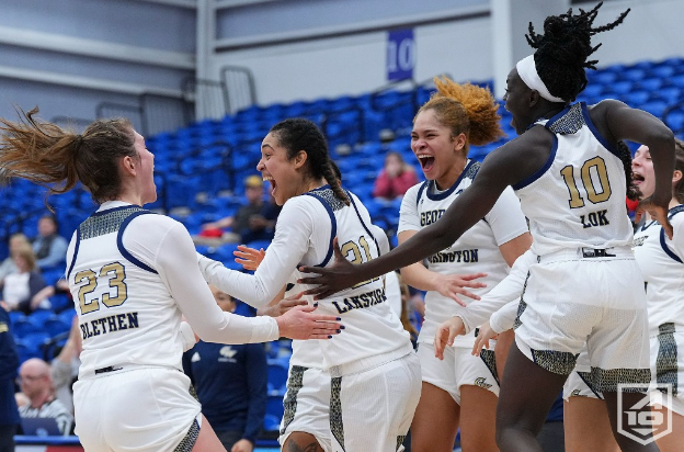 George Washington players jump up and down and celebrate an A-10 Tournament win.