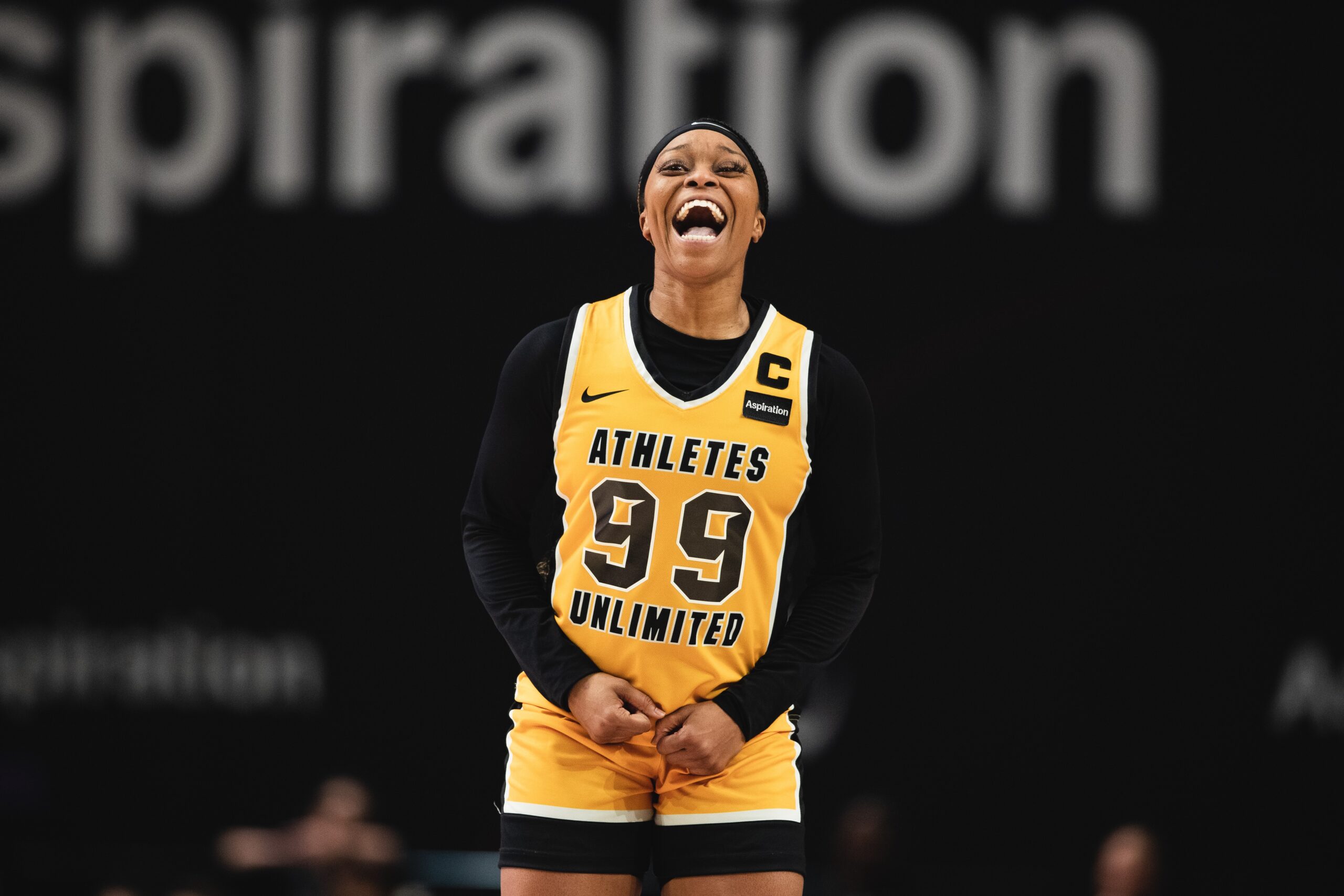 Odyssey Sims yells in celebration in a yellow Athletes Unlimited jersey