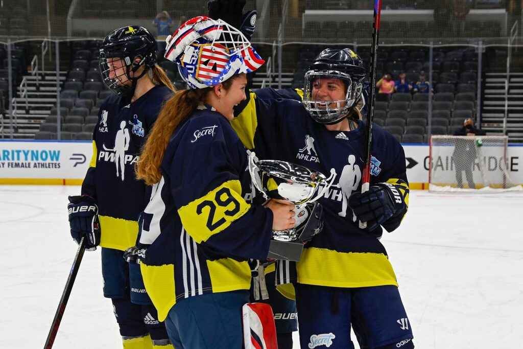 Two players from Team Minnesota hold the trophy at the 2021 St. Louis Showcase.