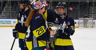 Two players from Team Minnesota hold the trophy at the 2021 St. Louis Showcase.