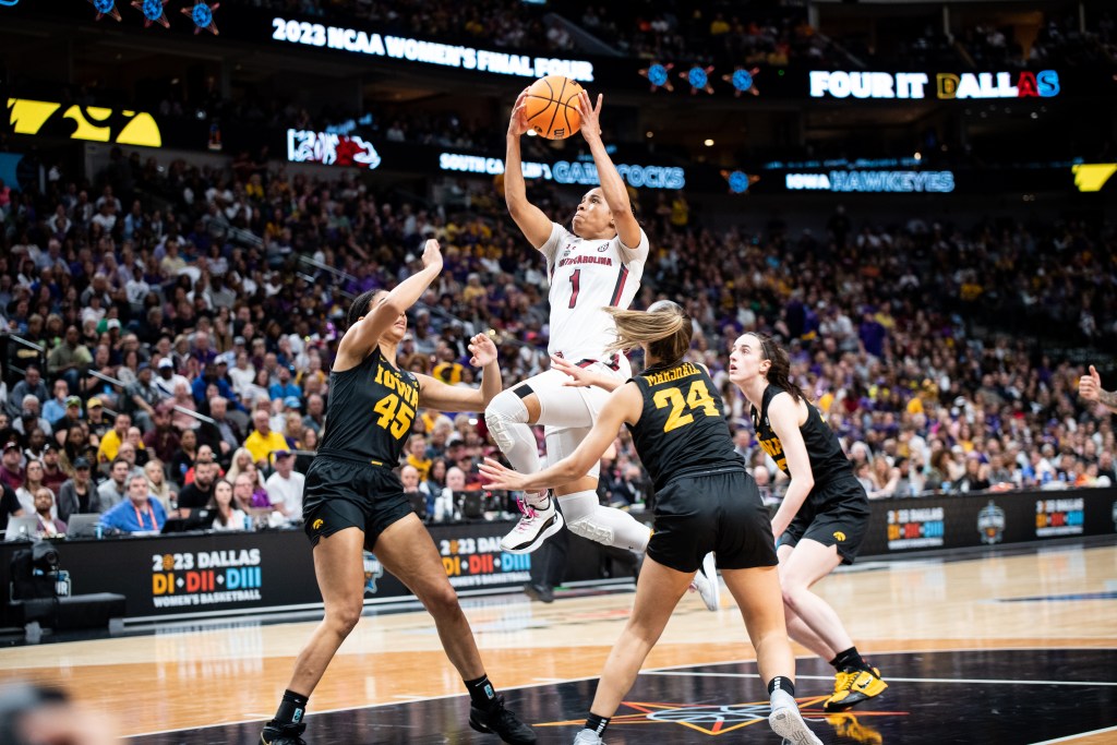 South Carolina guard Zia Cooke holds the ball above her head, ready to shoot, as she glides through the air.