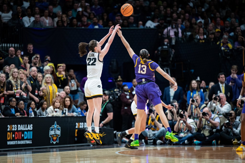LSU point guard Last-Tear Poa uses her left hand to contest a 3-pointer by Iowa guard Caitlin Clark.