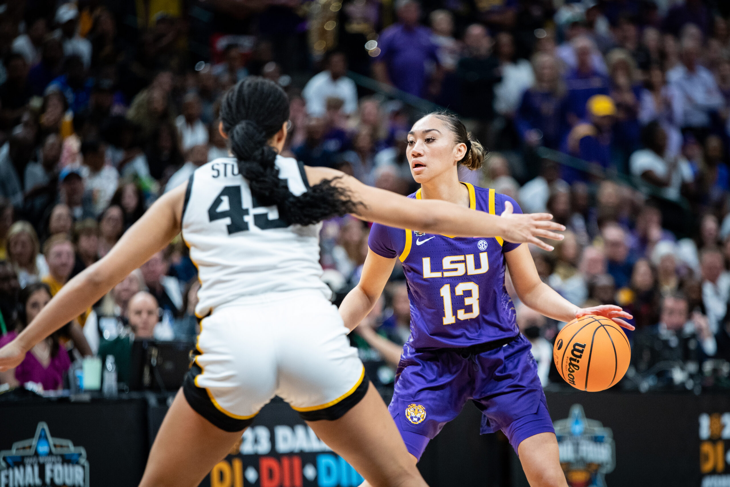 LSU point guard Last-Tear Poa dribbles the ball with her left hand as Iowa forward Hannah Stuelke defends.