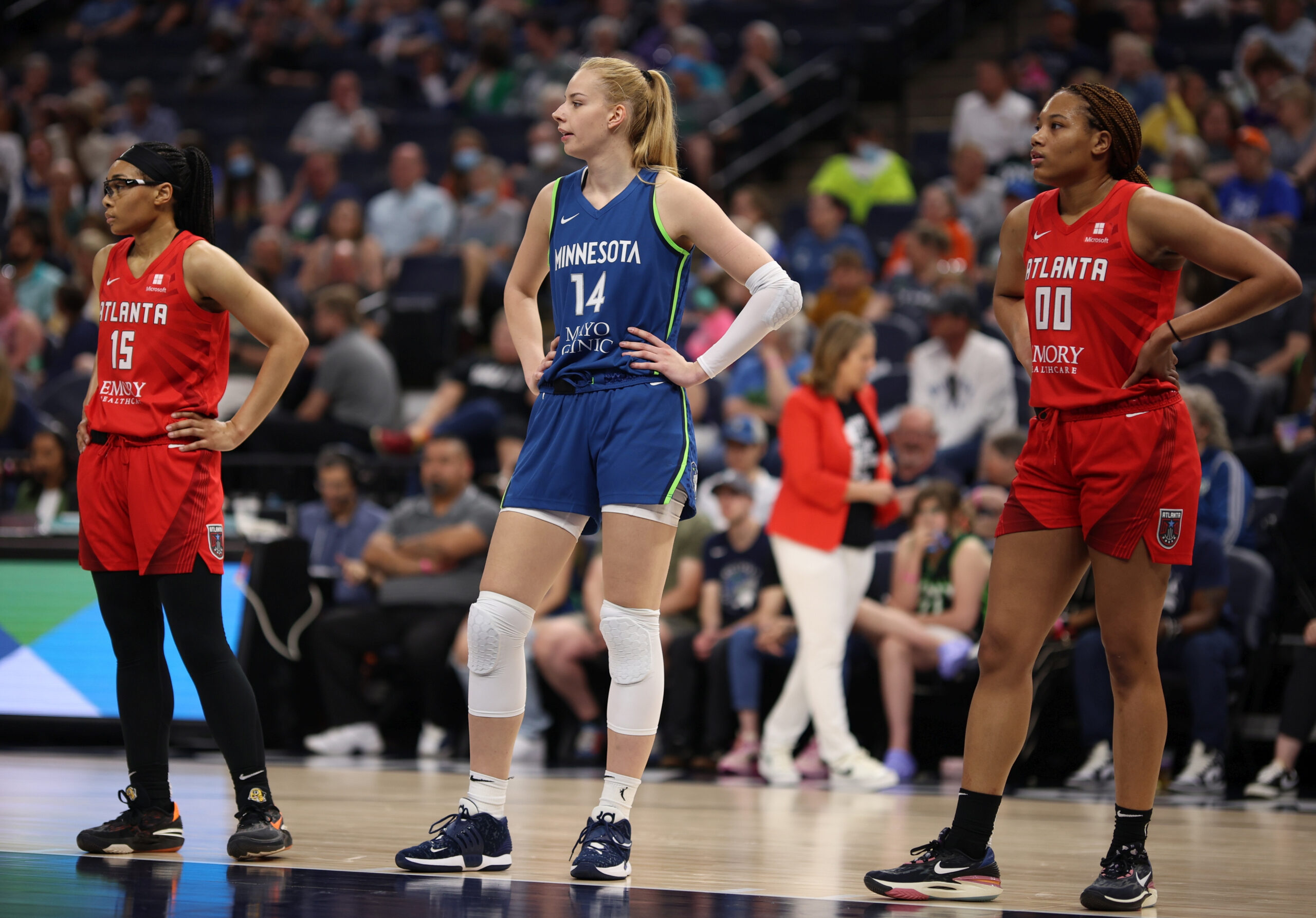Dorka Juhász stands between two Atlanta Dream players with her hands on their hips as they prepare for a free throw.