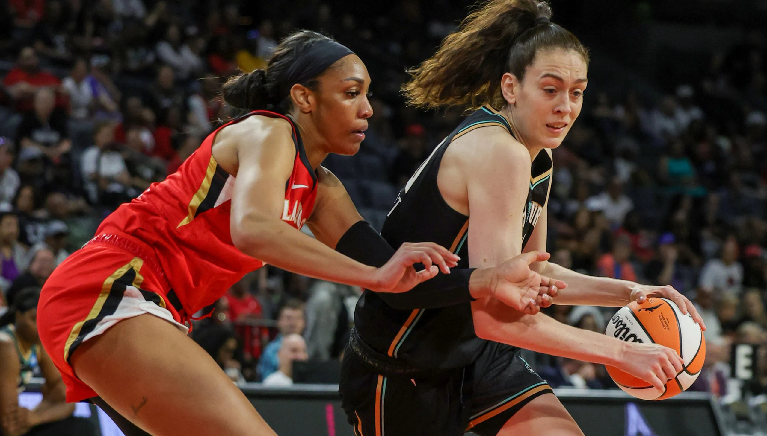 New York Liberty big wing Breanna Stewart dribbles downhill while Las Vegas Aces center A'ja Wilson defends her from the side, in a matchup of WNBA preseason favorites.