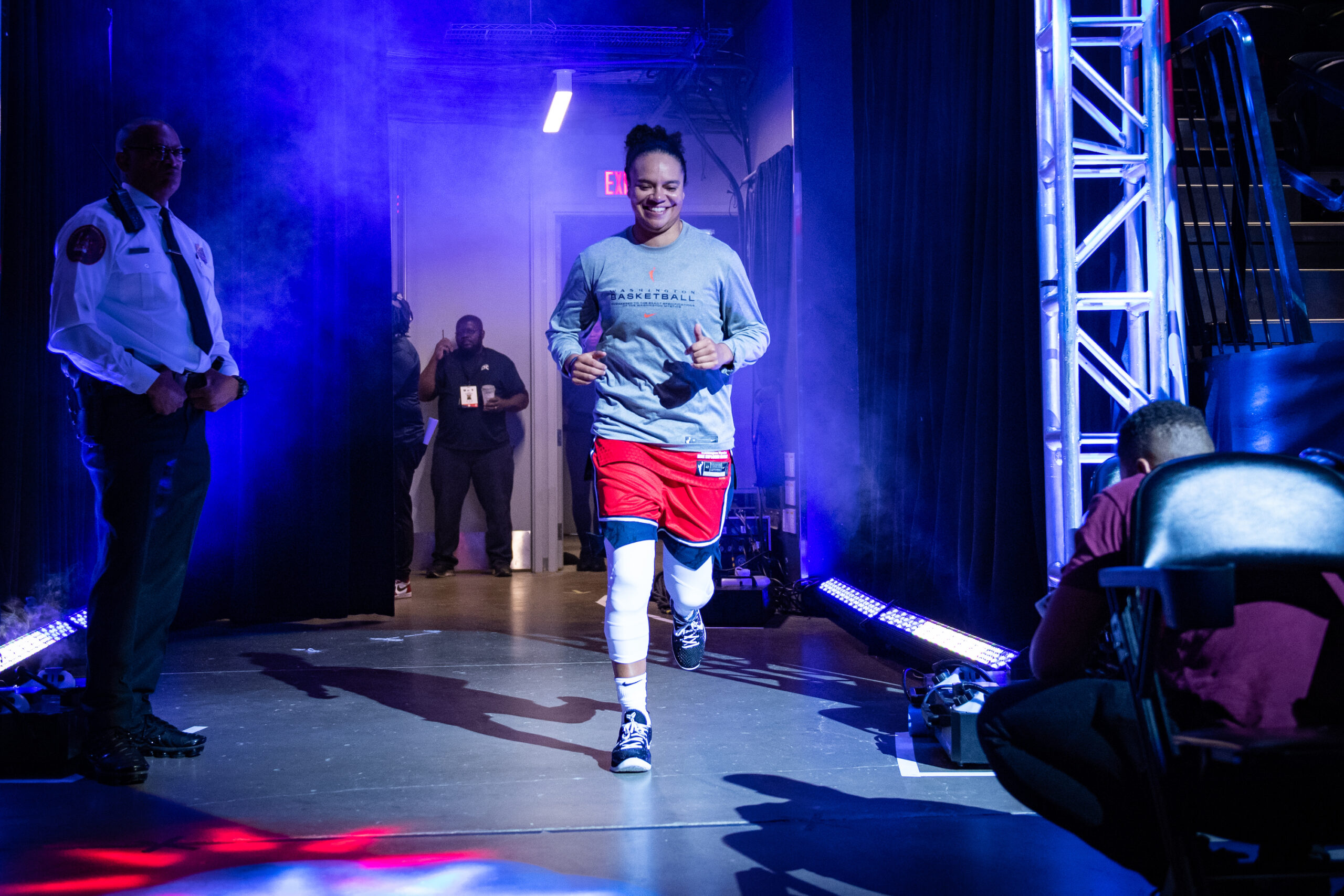 Kristi Toliver runs onto the court as a spotlight shines on her.