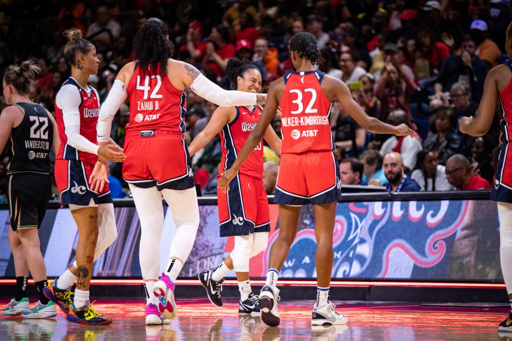 Washington Mystics guard Kristi Toliver grins as she gets ready to high-five her teammates.