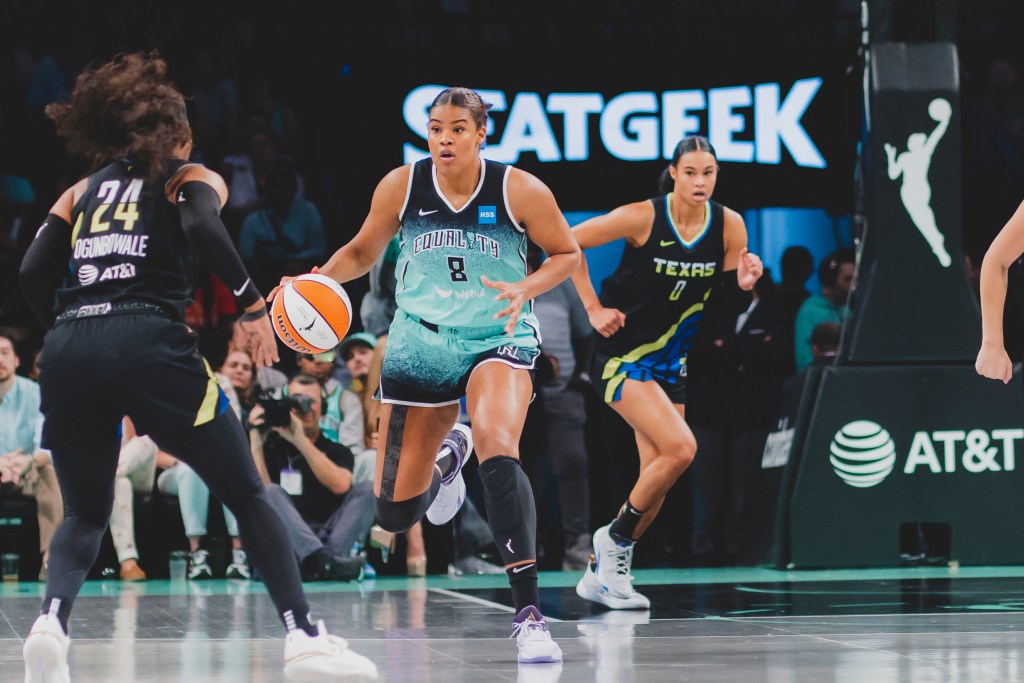 Nyara Sabally dribbles the ball with her sister Satou trailing behind her