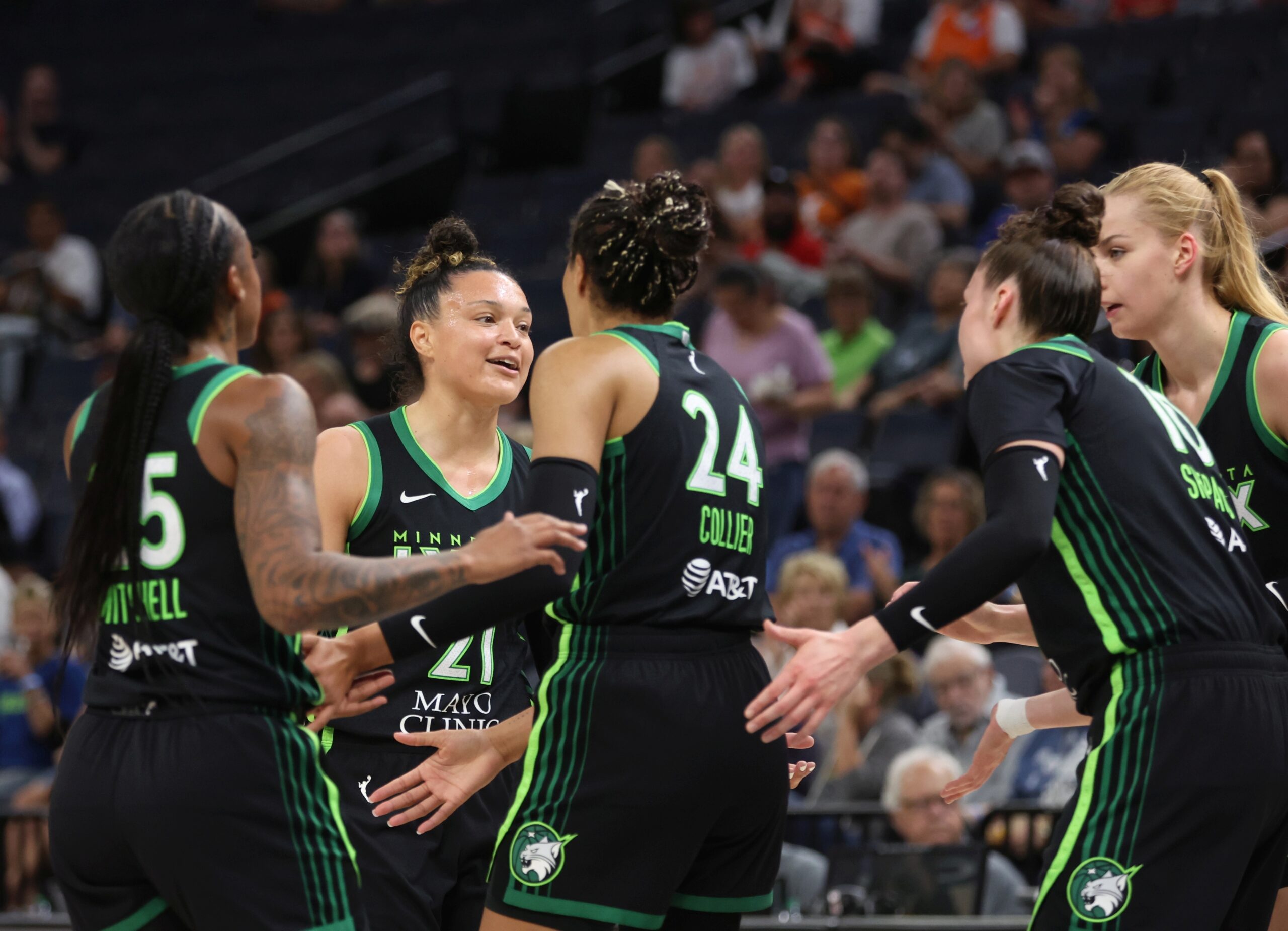 Minnesota Lynx guard Kayla McBride is greeted by several teammates during a game against the Connecticut Sun.