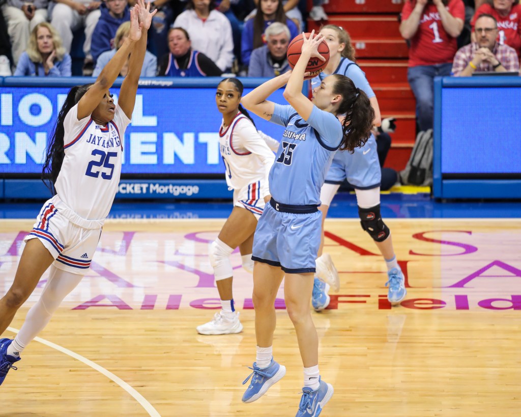 Columbia guard Abbey Hsu shoots a 3-pointer from near the top of the key as Kansas guard Chandler Prater leaps toward her to contest it.