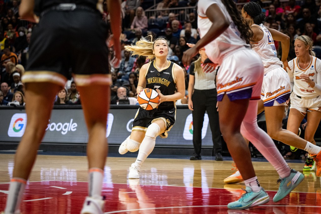 Washington Mystics guard Li Meng gathers her dribble just outside of the paint as Phoenix Mercury defenders try to react.