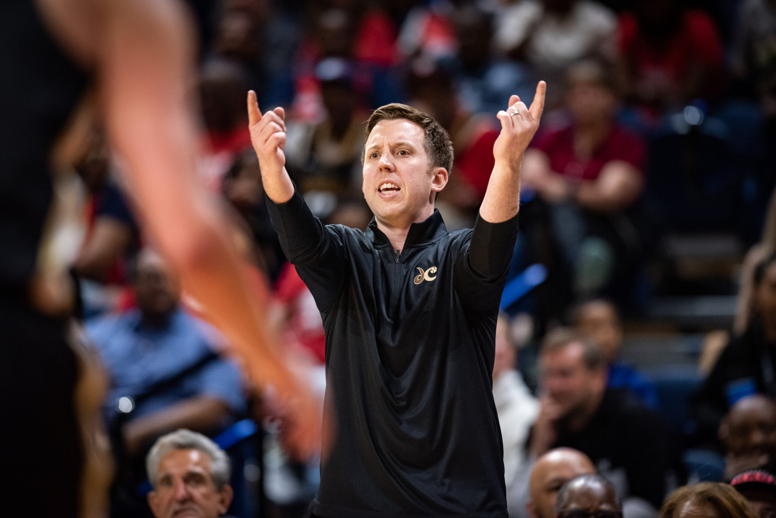Washington Mystics head coach Eric Thibault extends both arms in front of him with his index fingers pointed and his palms facing up.
