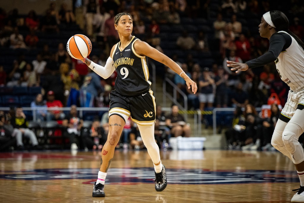 Washington Mystics guard Natasha Cloud plants her right foot as she prepares to throw a one-handed pass with her right hand.