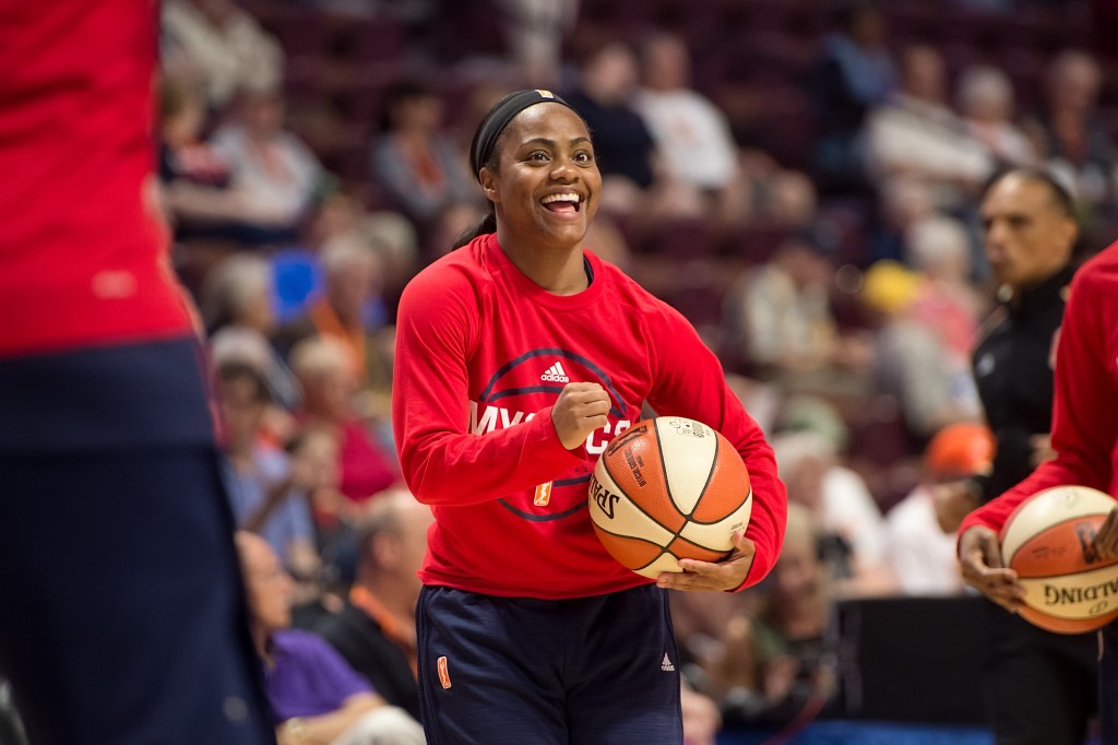 Washington Mystics guard Ivory Latta holds a ball and flashes a wide smile during warm-ups.