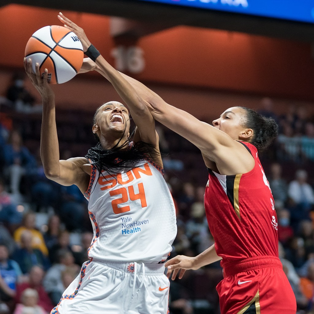 Connecticut Sun forward DeWanna Bonner attempts to shoot the ball, but Las Vegas Aces center Kiah Stokes reaches over and gets her left hand on the ball.