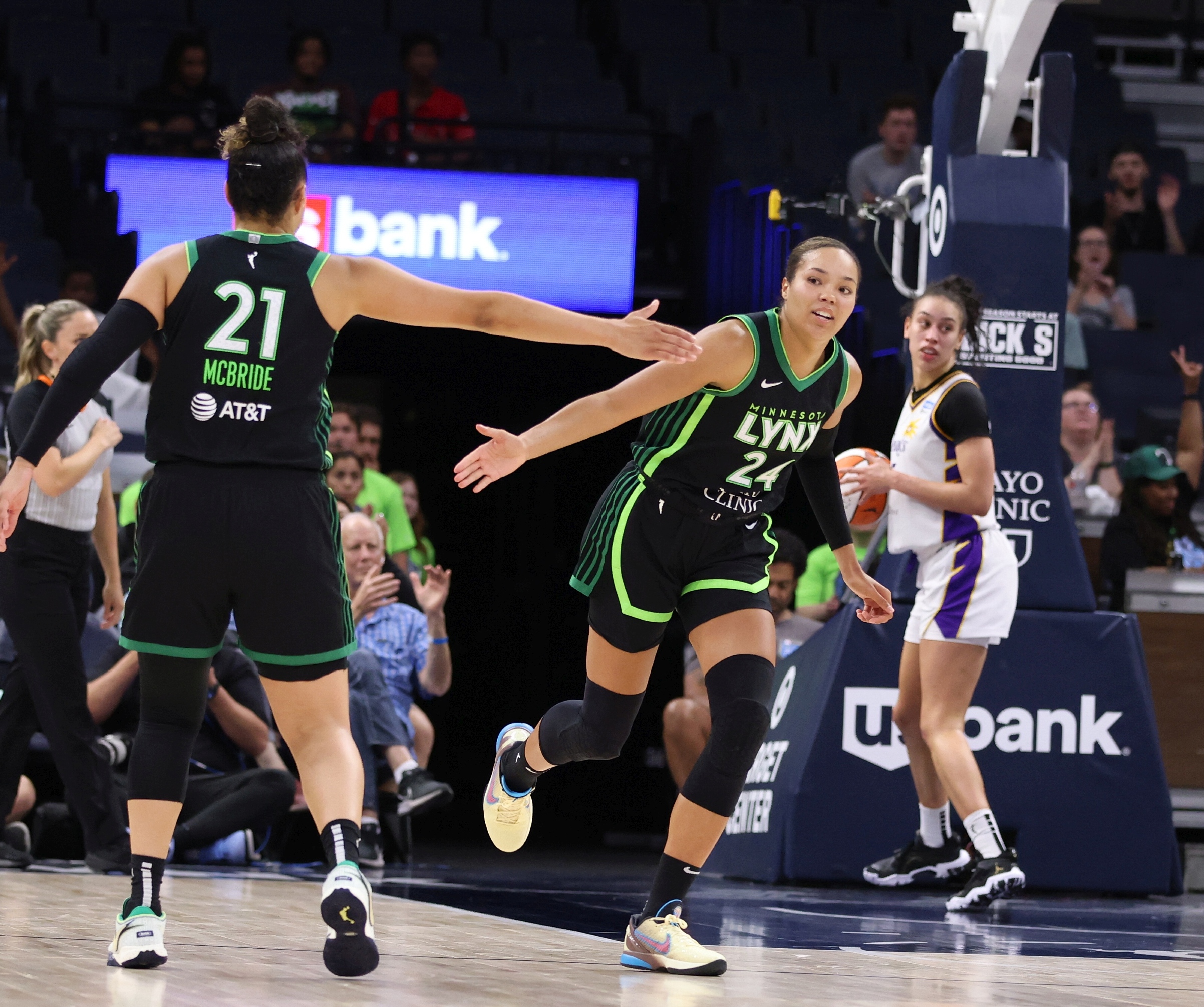 Napheesa Collier of the Minnesota Lynx runs up the court and high-fives teammate Kayla McBride against the Los Angeles Sparks