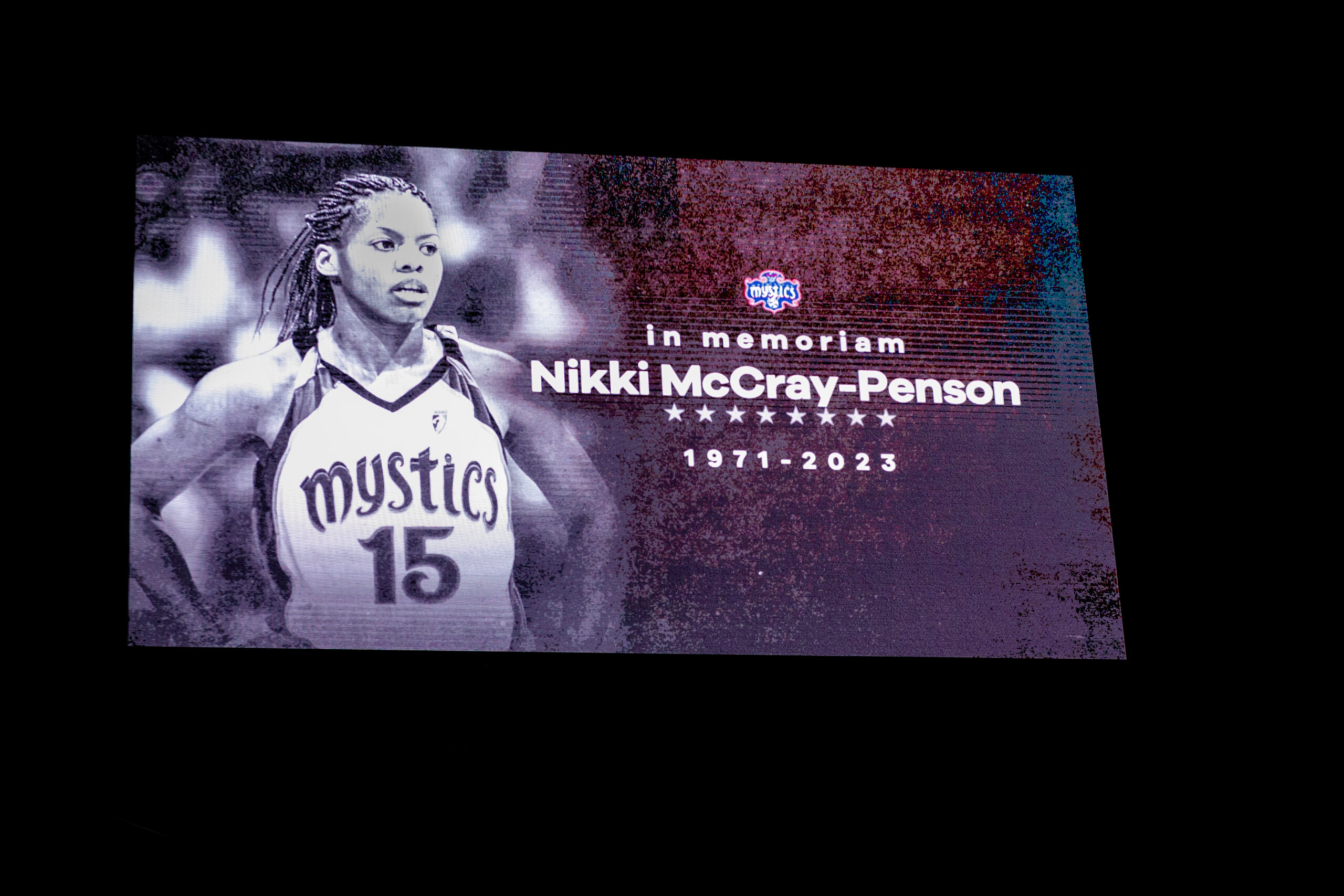 A photo of the scoreboard screen showing Nikki McCray-Penson, the Washington Mystics logo and the words "in memoriam Nikki McCray-Penson 1971-2023"