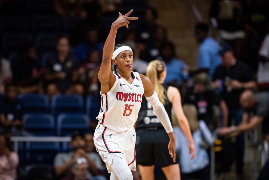 Washington Mystics guard Brittney Sykes holds three fingers in the air and sticks her tongue out in celebration.