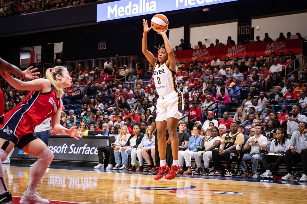 Indiana Fever guard Kelsey Mitchell shoots a mid-range jump shot with her left hand. No defender is close enough to contest it.