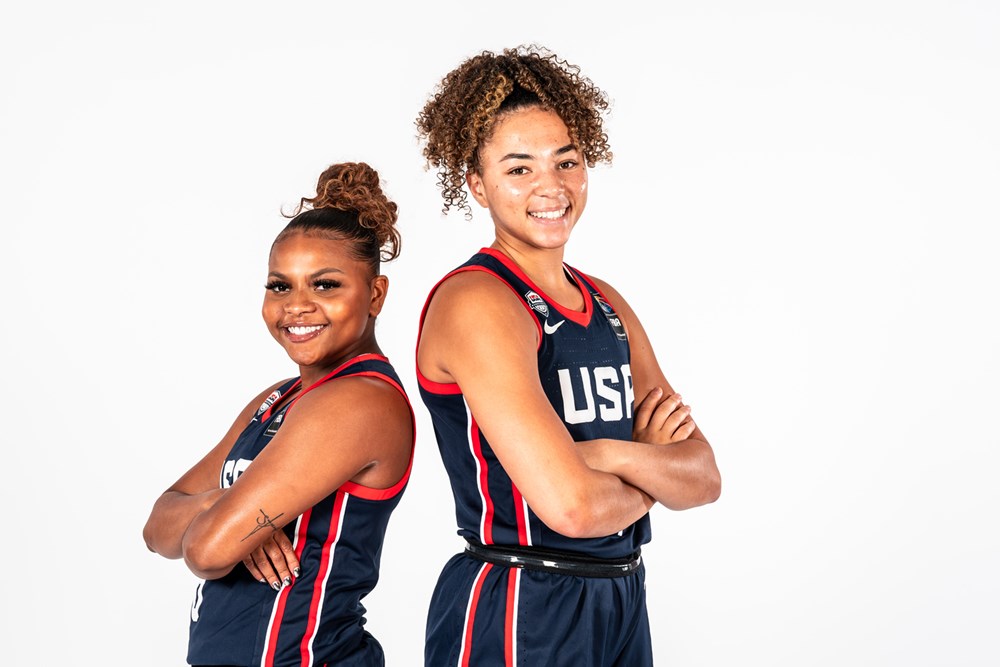 Team USA and UCLA teammates Londynn Jones and Kiki Rice stand back-to-back with their arms crossed over their chests and smile for a photo.