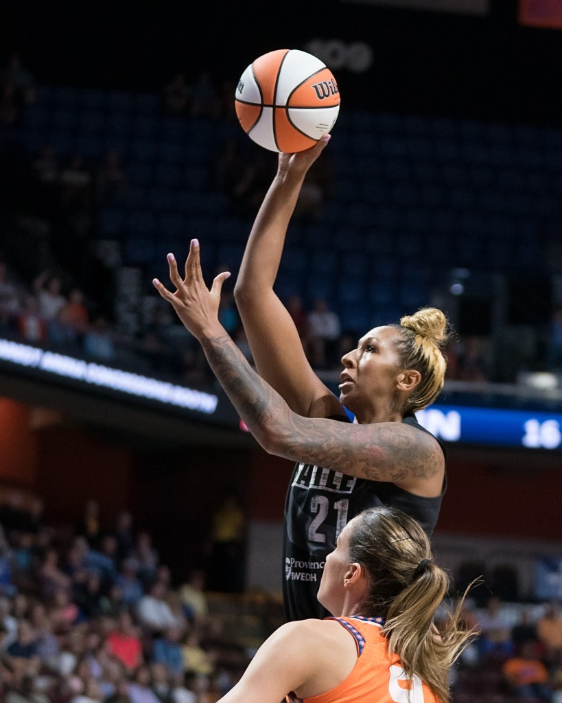 Mercedes Russell rises above a Connecticut defender looking to shoot. She has the ball high in the air in her right hand.