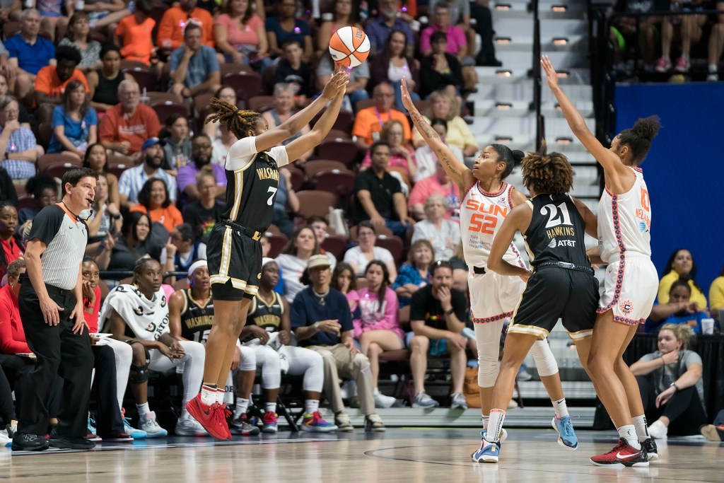 Washington Mystics guard Ariel Atkins shoots a deep 3-pointer as Connecticut Sun guard Tyasha Harris tries to contest.