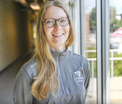 Stefanie McKeough is pictured in a grey sweatshirt with the uOttawa Hockey logo emblazened in white on the top left shoulder.
