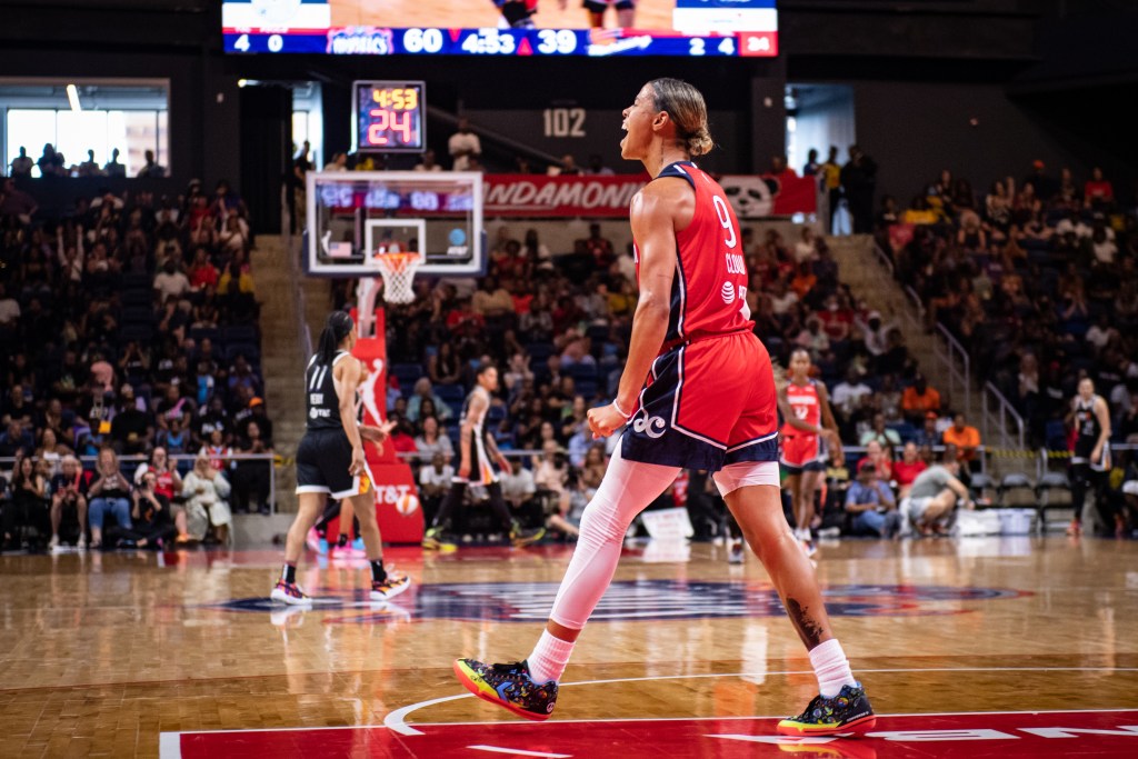 Washington Mystics point guard Natasha Cloud clenches her fists and yells as she walks across the court near the free-throw line.