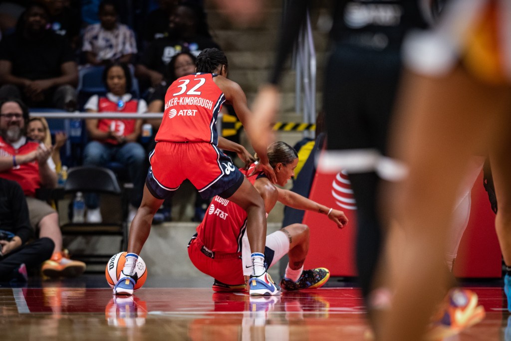 Washington Mystics guard Shatori Walker-Kimbrough is pictured from behind giving guard Natasha Cloud a shoulder massage to celebrate a good play.