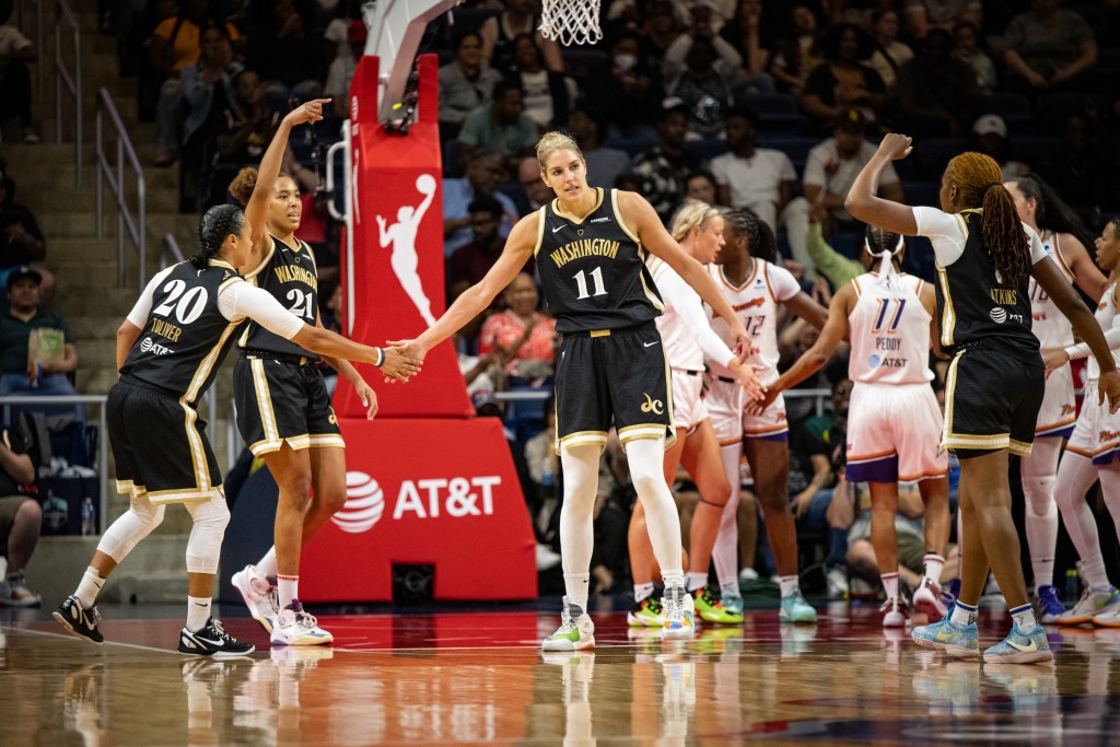 Washington Mystics forward Elena Delle Donne extends her right hand to high-five guard Kristi Toliver as two of their teammates approach them with hands raised in the air in celebration.