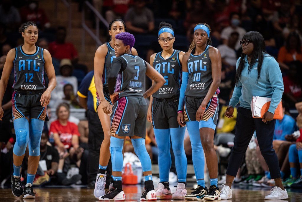 Danielle Robinson (No. 3) pictured alongside teammates and assistant coach Barbara Turner during a road game in Washington