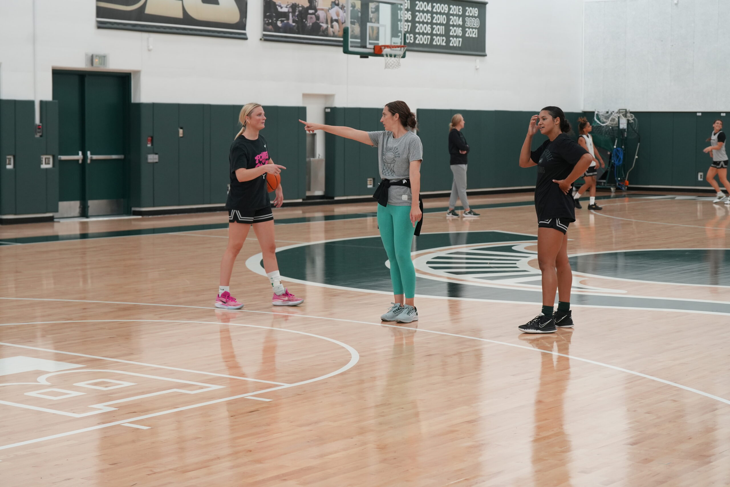 Michigan State head coach Robyn Fralick works with Theryn Hallock and Moira Joiner at practice.