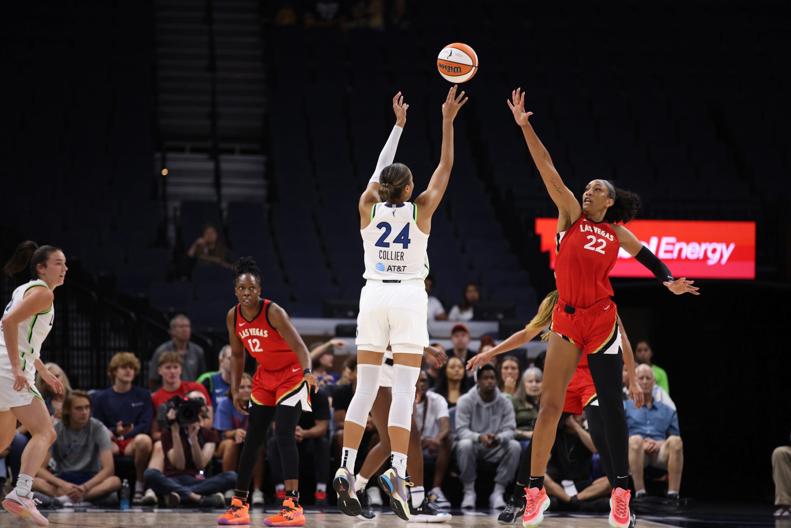 Minnesota Lynx big Napheesa Collier releases a jump shot off her fingertips as Las Vegas Aces big A'ja Wilson jumps toward her with an outstretched arm to contest the shot in a WNBA game.