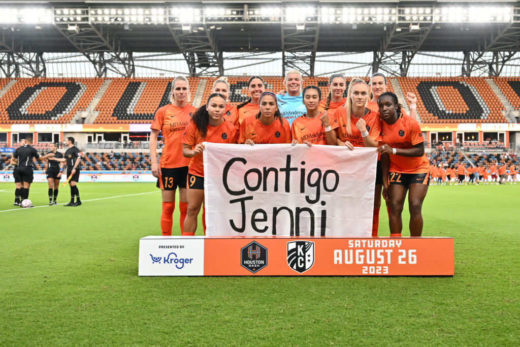 Aug 26, 2023; Houston, Texas, USA; The starting eleven for Houston Dash hold a sign in support of Spanish womenÕs team forward Jenni Hermoso before the match against the Kansas City Current at Shell Energy Stadium. Mandatory Credit: Maria Lysaker-USA TODAY Sports