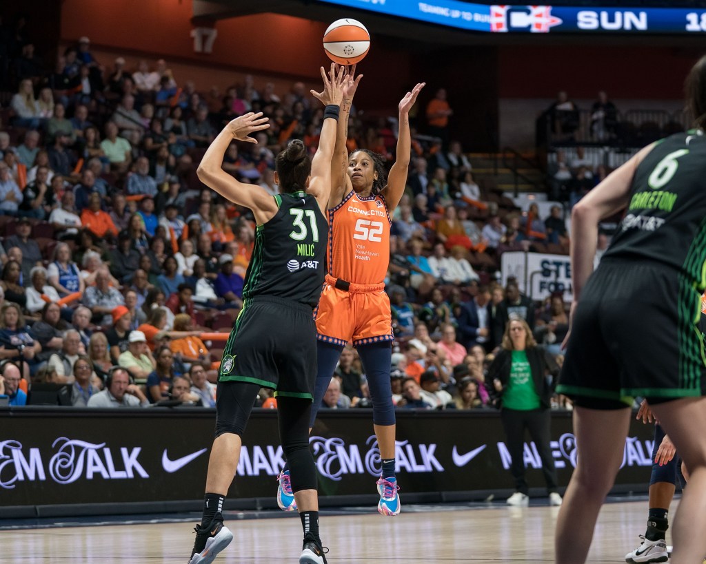 Connecticut Sun guard Tyasha Harris releases a right-handed jump shot over Minnesota Lynx forward Nikolina Milic, who closes out with her right hand up.