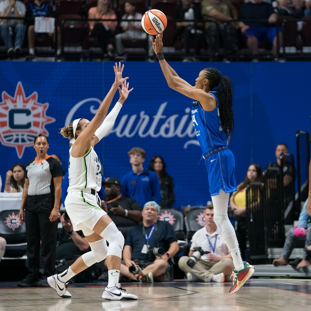 Connecticut Sun forward/guard DeWanna Bonner shoots a jump shot as Minnesota Lynx forward Napheesa Collier closes out with two hands up.