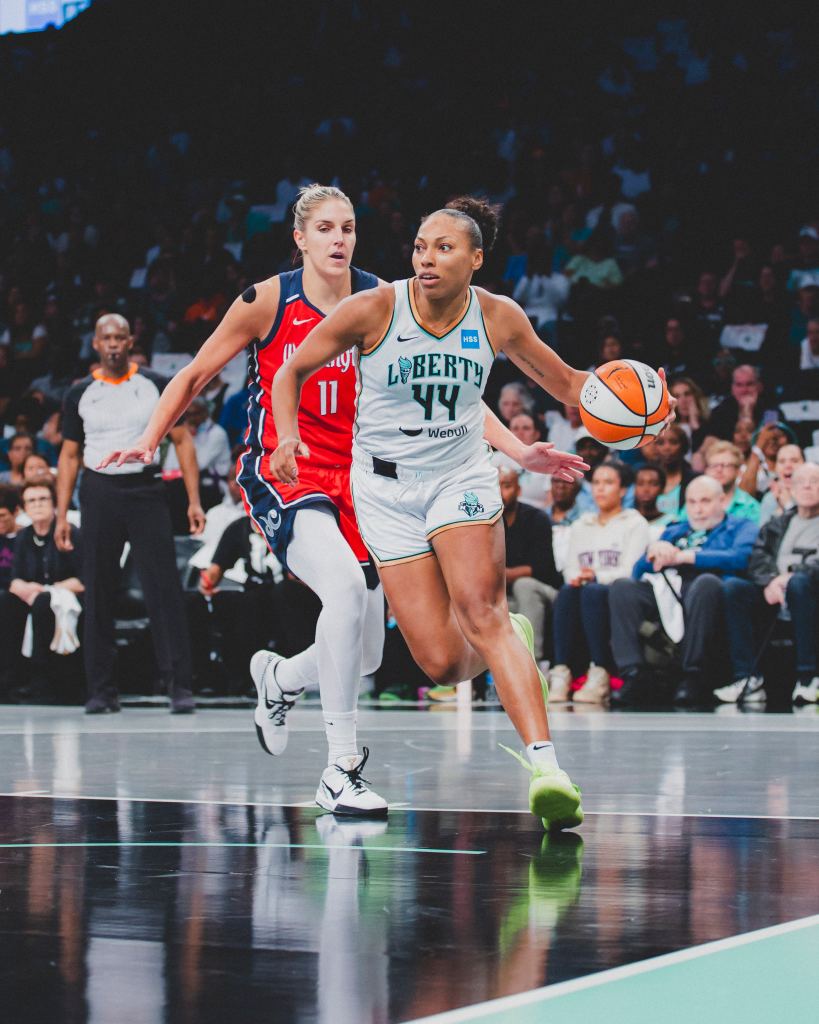 Betnijah Laney drives the ball with her left hand as Elena Delle Donne trails her.