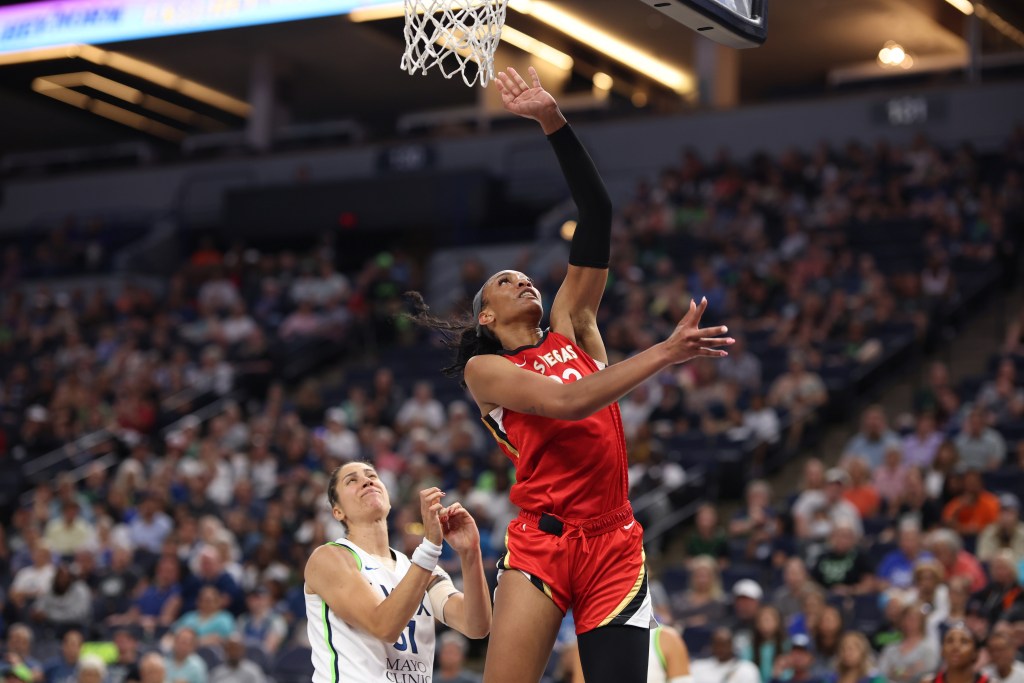 Las Vegas Aces forward A'ja Wilson shoots a left-handed layup as Minnesota Lynx forward Nikolina Milic arrives too late to contest.