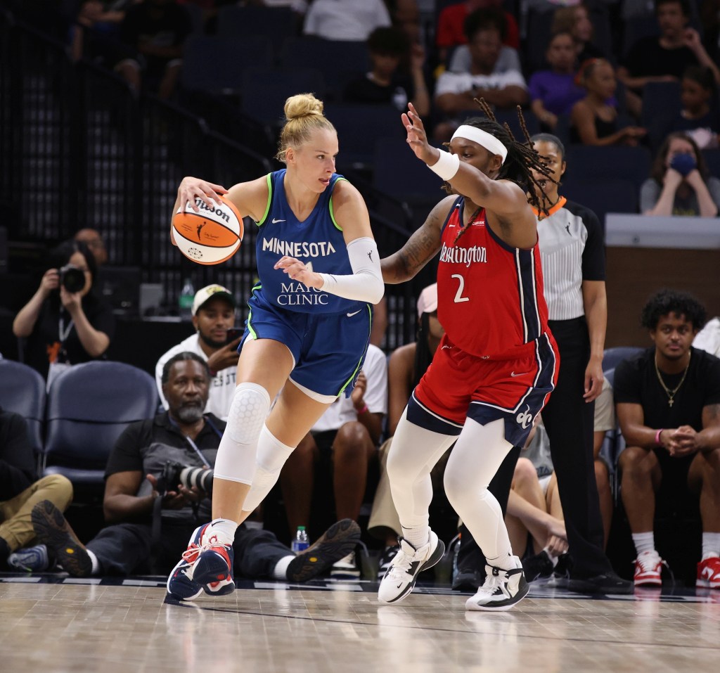Washington Mystics forward Myisha Hines-Allen moves laterally as Minnesota Lynx forward Dorka Juhász dribbles the ball with her right hand.