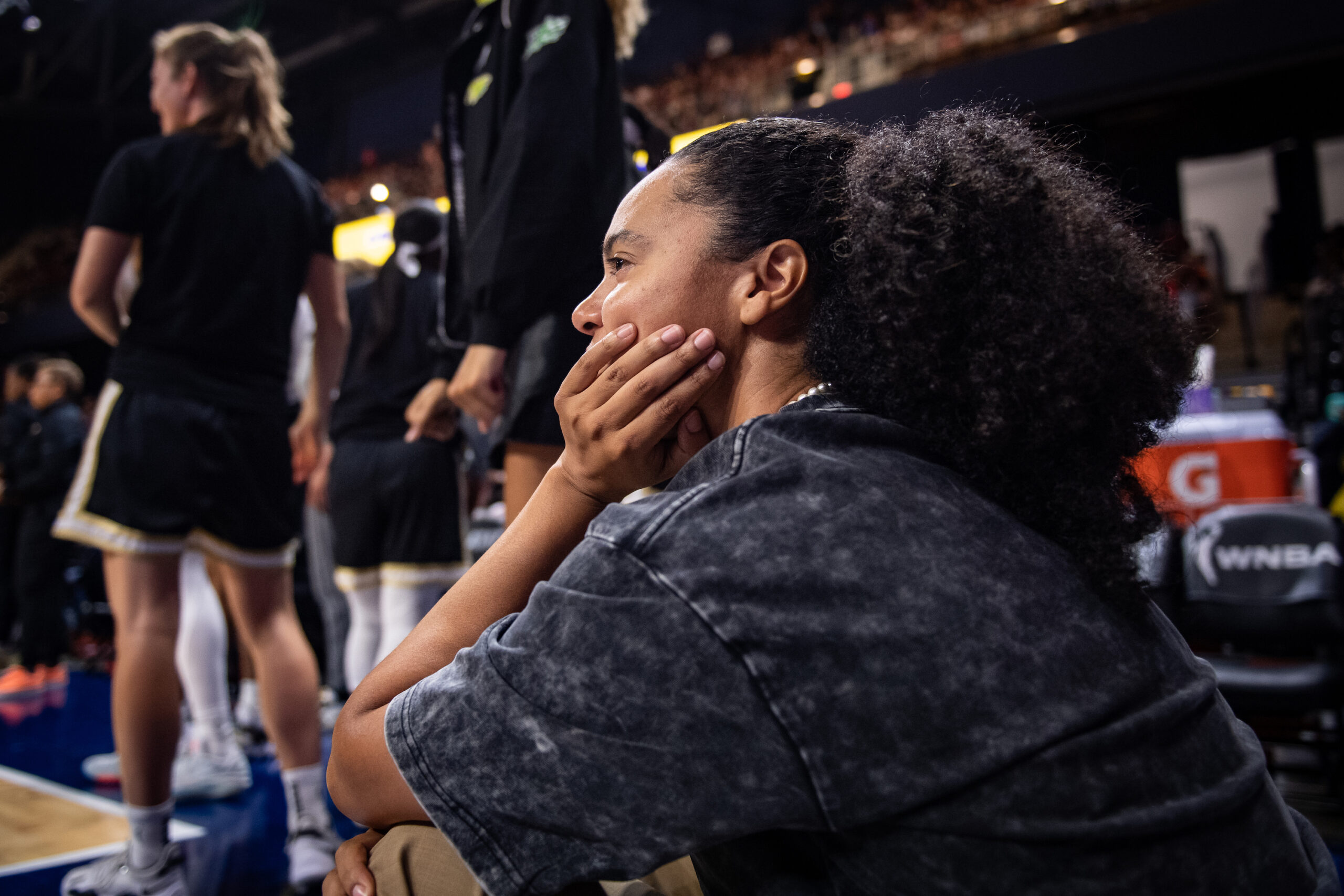 A close-up, side-angle photo of Washington Mystics guard Kristi Toliver watching a game in street clothes.