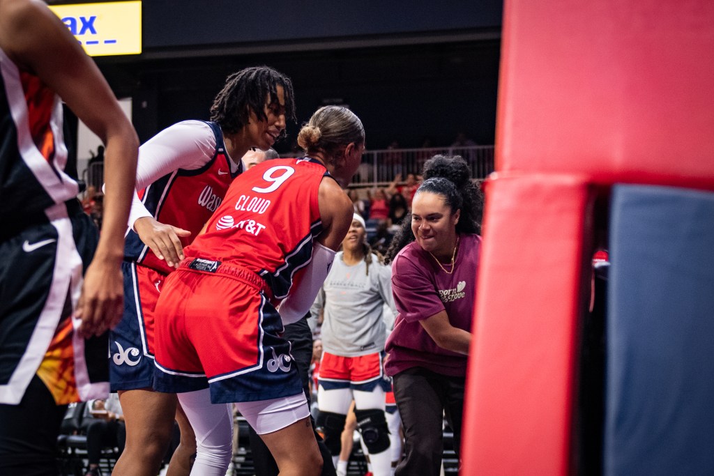 Washington Mystics guard Kristi Toliver is shown just after high-fiving guard Natasha Cloud in the out-of-bounds area under the basket.