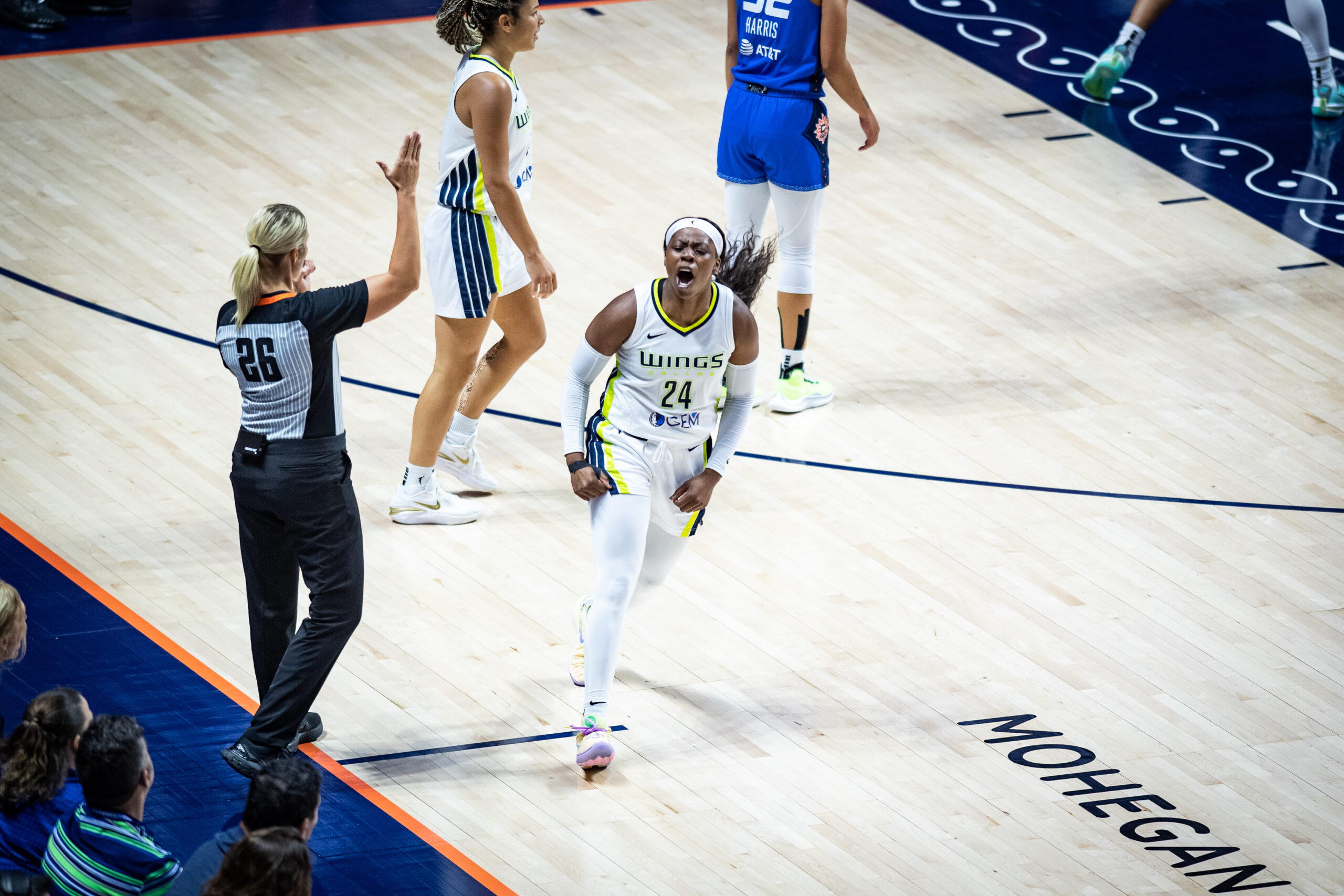 Dallas Wings guard Arike Ogunbowale clenches her fists and shouts in celebration during a game.