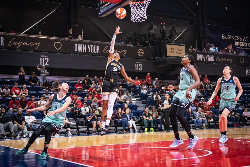 Washington Mystics guard Natasha Cloud shoots an open right-handed layup. Three New York Liberty players watch, unable to contest.