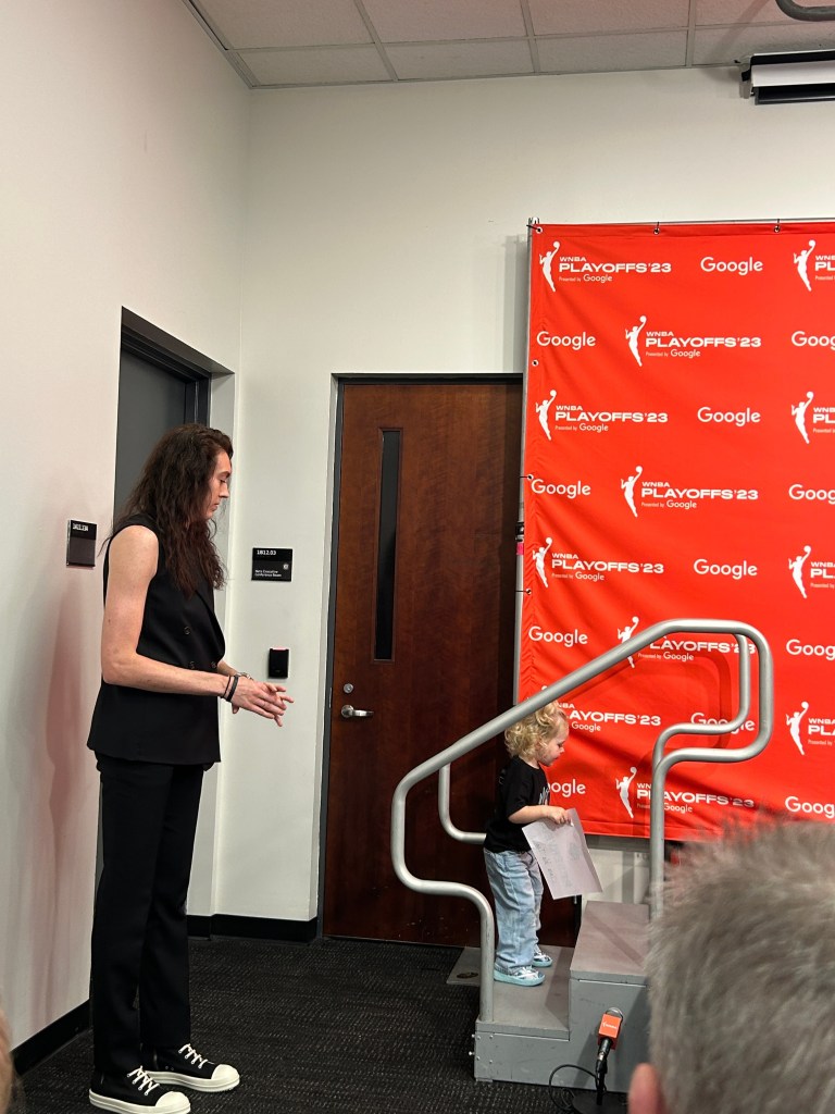 Breanna Stewart and her daughter Ruby listen to Cathy Engelbert speak ahead of giving Stewart the 2023 WNBA MVP Award. (Howard Megdal photo)