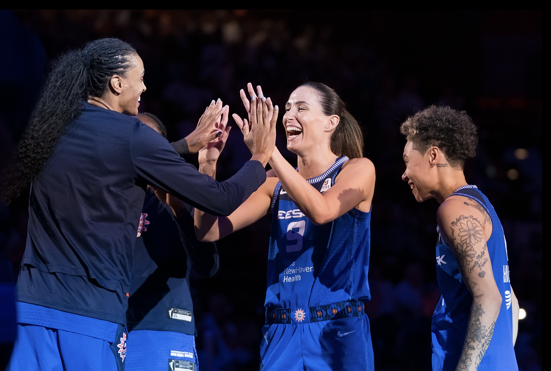 Connecticut Sun guard Rebecca Allen smiles and high-fives teammate DeWanna Bonner as she is introduced before a game.
