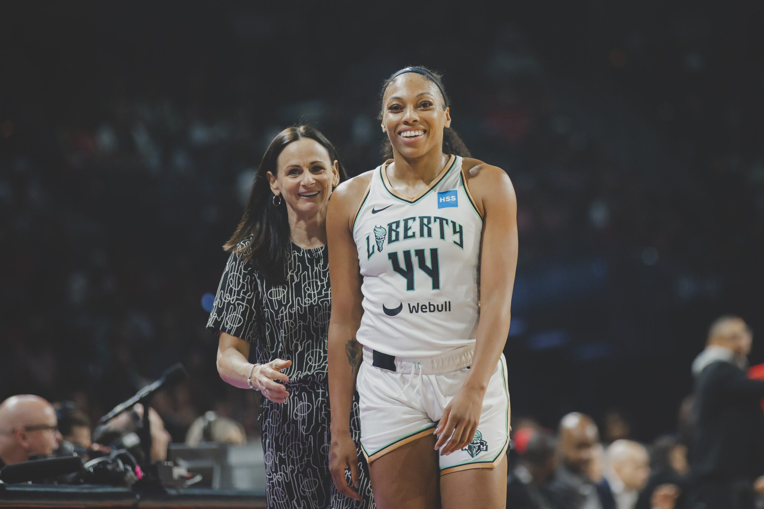 Sandy Brondello and Betnijah Laney smile while walking on the sideline.