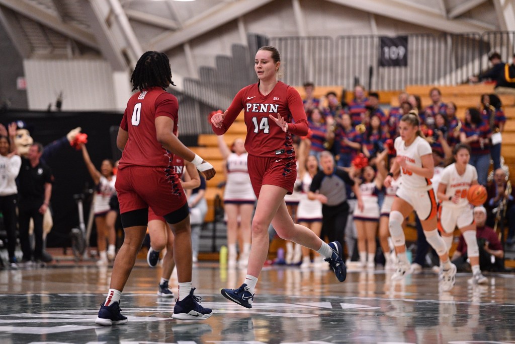 Penn forwards Floor Toonders and Jordan Obi high-five as they run back on defense during an Ivy League Tournament semifinal game.