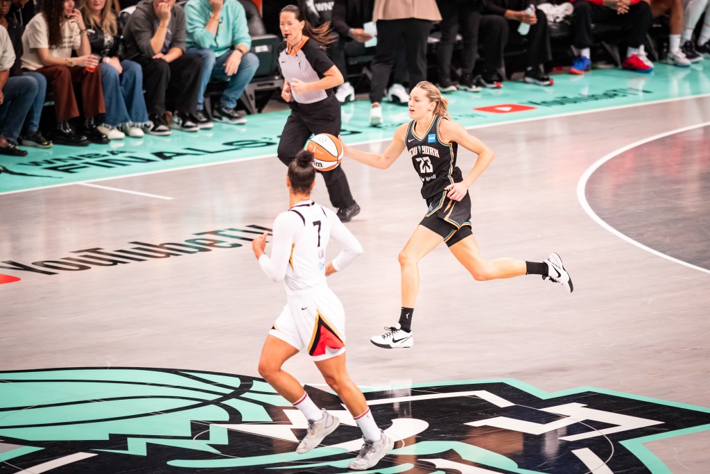 New York Liberty guard Marine Johannès dribbles the ball over half court with her right hand.