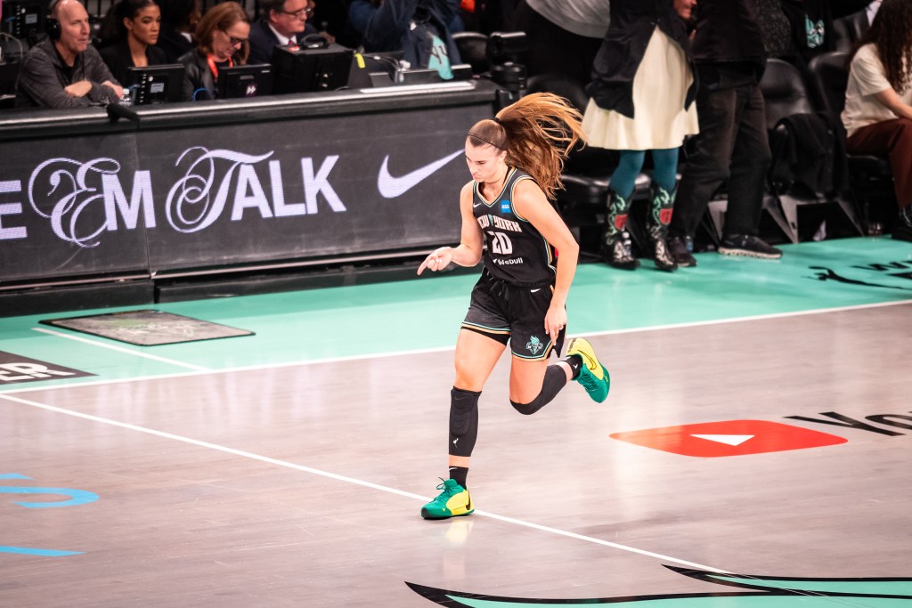 New York Liberty guard Sabrina Ionescu points her finger down in celebration after making a shot.